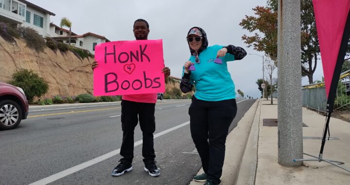 People cheering on the street holding a sign